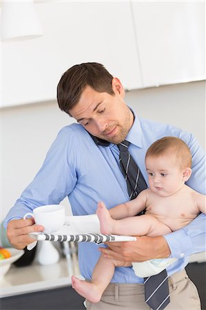 simsearch:6102-08858419,k - Busy father holding his baby son before work Stock Photo - Premium Royalty-Free, Code: 6109-07601347