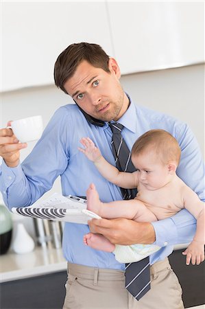 simsearch:6102-08858419,k - Busy father holding his baby son before work Stock Photo - Premium Royalty-Free, Code: 6109-07601348