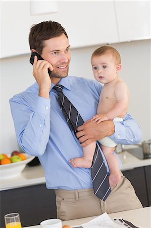 simsearch:6102-08858419,k - Busy father holding his baby son before work Stock Photo - Premium Royalty-Free, Code: 6109-07601349