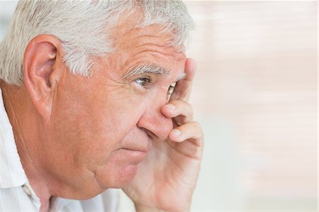 Unhappy senior man sitting on the couch Stock Photo - Premium Royalty-Free, Code: 6109-07601366