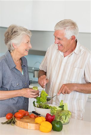 Smiling senior couple preparing a salad Foto de stock - Sin royalties Premium, Código: 6109-07601376