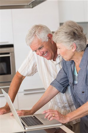 simsearch:6109-07601432,k - Happy senior couple using the laptop at the counter Stock Photo - Premium Royalty-Free, Code: 6109-07601389