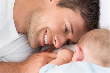 simsearch:6109-07601273,k - Happy father lying with baby son sleeping Stock Photo - Premium Royalty-Free, Code: 6109-07601314