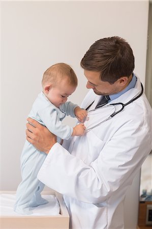 Handsome pediatrician holding baby boy Stock Photo - Premium Royalty-Free, Code: 6109-07601333