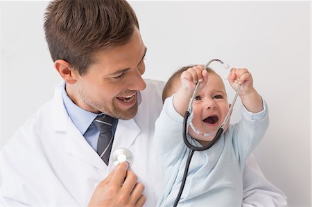 Handsome pediatrician holding baby boy Stock Photo - Premium Royalty-Free, Code: 6109-07601335