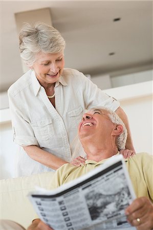 elderly couple on sofa - Senior man reading newspaper with partner leaning on shoulders Stock Photo - Premium Royalty-Free, Code: 6109-07601468