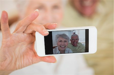 senior sitting on couch - Senior woman taking a selfie with her smartphone Stock Photo - Premium Royalty-Free, Code: 6109-07601472