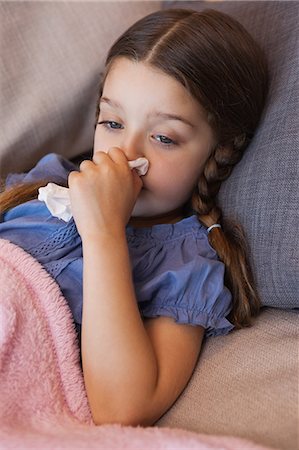 sick home - Close-up of a girl blowing nose with tissue paper Stock Photo - Premium Royalty-Free, Code: 6109-07601488