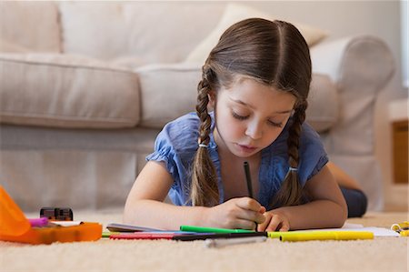 Close-up of a little girl drawing in living room Photographie de stock - Premium Libres de Droits, Code: 6109-07601496