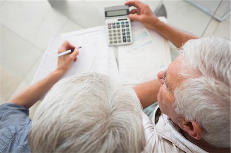 Senior couple using the calculator to pay bills Stock Photo - Premium Royalty-Free, Code: 6109-07601405