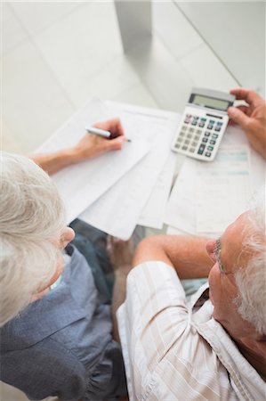 Senior couple using the calculator to pay bills Stock Photo - Premium Royalty-Free, Code: 6109-07601406