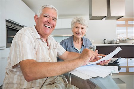 elderly couple in home - Happy couple paying their bills at the table Photographie de stock - Premium Libres de Droits, Code: 6109-07601409