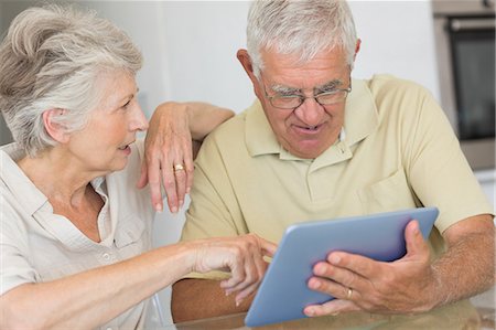 ratlos - Happy senior couple using tablet pc at the table Foto de stock - Sin royalties Premium, Código: 6109-07601432