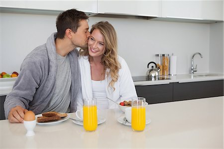 robe man - Man kissing happy woman at breakfast table Stock Photo - Premium Royalty-Free, Code: 6109-07601554
