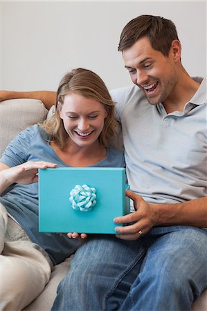 Happy woman receiving a gift by man in living room Stock Photo - Premium Royalty-Free, Code: 6109-07601571