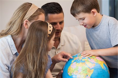 people holding globe - Close-up of a family of four looking at globe Stock Photo - Premium Royalty-Free, Code: 6109-07601517