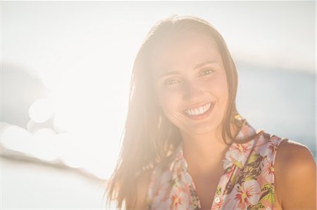 simsearch:6109-07496983,k - Pretty brunette relaxing beside the water looking at camera Stock Photo - Premium Royalty-Free, Code: 6109-08203033