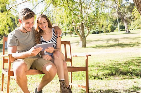 Cute couple sitting on the bench and using tablet Stock Photo - Premium Royalty-Free, Code: 6109-08203129