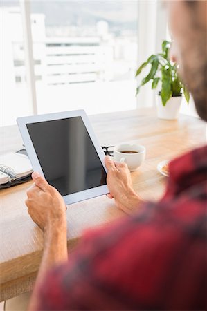 simsearch:6109-08203288,k - Man holding tablet at desk Stock Photo - Premium Royalty-Free, Code: 6109-08203244