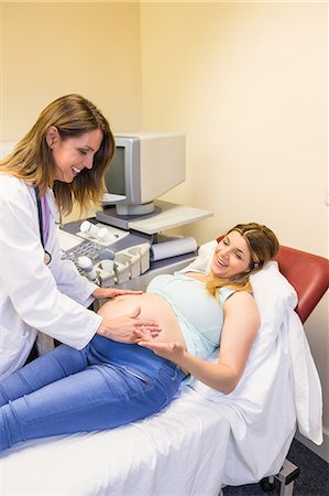 Smiling doctor looking at pregnant patient Foto de stock - Sin royalties Premium, Código: 6109-08203362