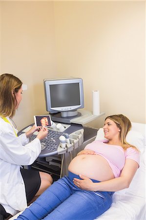 female body lying down - Doctor showing picture to the smiling pregnant woman Stock Photo - Premium Royalty-Free, Code: 6109-08203383