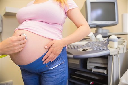 simsearch:6109-08203361,k - Young Doctor checking her pregnant patient Stock Photo - Premium Royalty-Free, Code: 6109-08203390