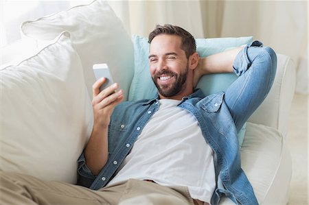 flat lay - Smiling man sending a text message Photographie de stock - Premium Libres de Droits, Code: 6109-08203588