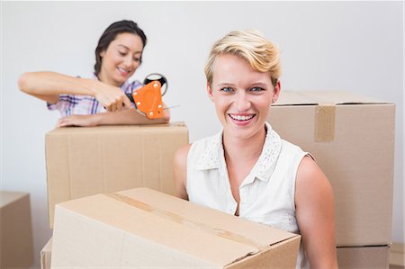 Smiling lesbian couple holding cardboard boxes Fotografie stock - Premium Royalty-Free, Codice: 6109-08203530