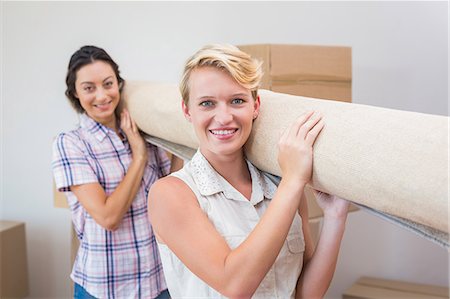 Lesbian couple holding a rolled up carpet Foto de stock - Royalty Free Premium, Número: 6109-08203531