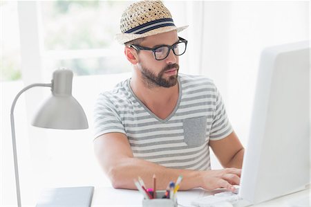 person working on computer at home - Serious handsome man using computer Stock Photo - Premium Royalty-Free, Code: 6109-08203644