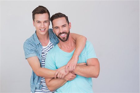 Happy homosexual couple looking at camera and hugging Stock Photo - Premium Royalty-Free, Code: 6109-08203697