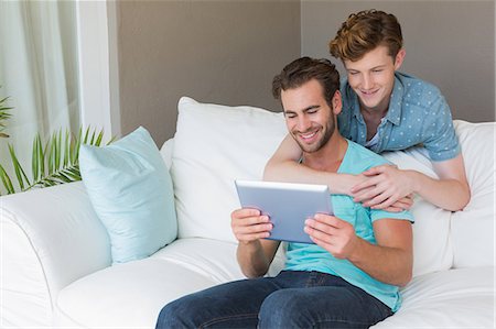 simsearch:6109-08390086,k - Cute homosexual couple using tablet on couch Foto de stock - Sin royalties Premium, Código: 6109-08203778