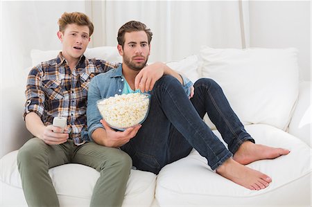 Homosexual couple eating pop corn on sofa Stockbilder - Premium RF Lizenzfrei, Bildnummer: 6109-08203796