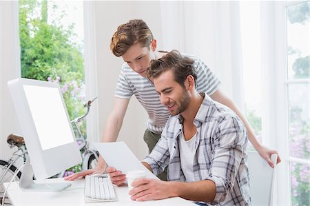 Happy casual businessmen looking at document Stock Photo - Premium Royalty-Free, Code: 6109-08203739