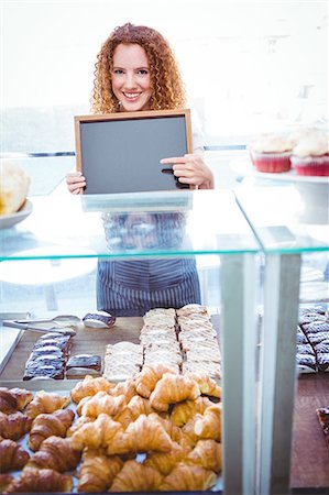 simsearch:6109-08395965,k - Happy pretty barista holding board Stock Photo - Premium Royalty-Free, Code: 6109-08203845