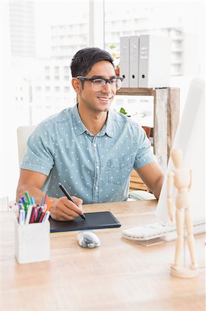 Smiling casual businessman using computer and digitizer Foto de stock - Sin royalties Premium, Código: 6109-08203899