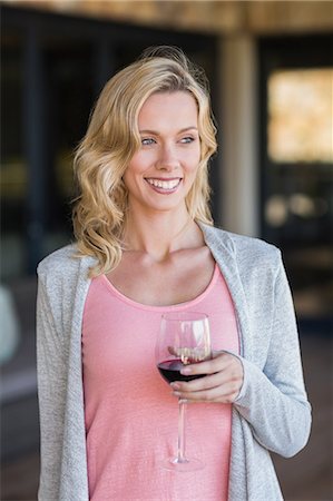 Smiling blonde woman standing and holding wineglass Photographie de stock - Premium Libres de Droits, Code: 6109-08203987