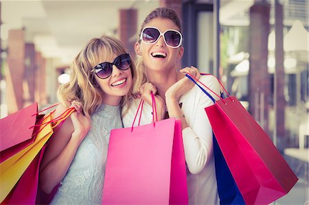 stores in outdoor mall - Beautiful women holding shopping bags looking at camera Stock Photo - Premium Royalty-Free, Code: 6109-08204121