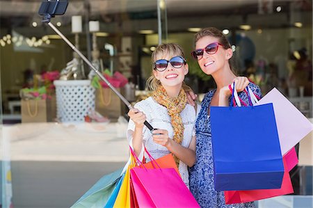 shopaholic (female) - Beautiful women holding shopping bags making a selfie Stock Photo - Premium Royalty-Free, Code: 6109-08204126