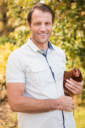 free range chicken - Happy farmer holding chicken Stock Photo - Premium Royalty-Free, Code: 6109-08204273