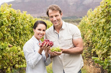 saisonier - Smiling couple showing a bunch of grapes Photographie de stock - Premium Libres de Droits, Code: 6109-08204218