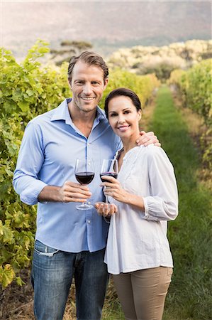 simsearch:6109-08204328,k - Smiling couple toasting with red wine Foto de stock - Sin royalties Premium, Código: 6109-08204235