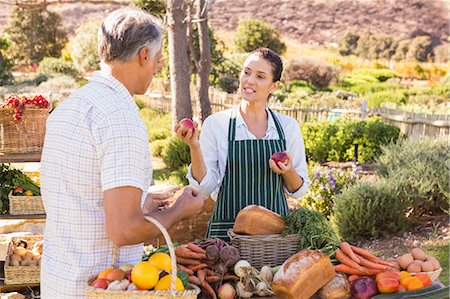 farmers market female - Smiling brunette farmer selling vegetables and bread Stock Photo - Premium Royalty-Free, Code: 6109-08204304