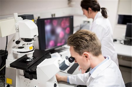 simsearch:6109-08389507,k - Scientist looking through a microscope Stock Photo - Premium Royalty-Free, Code: 6109-08389513