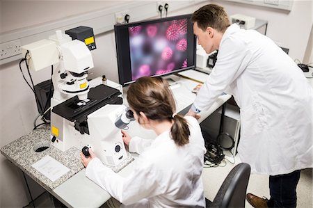 Scientist looking through a microscope Photographie de stock - Premium Libres de Droits, Code: 6109-08389510