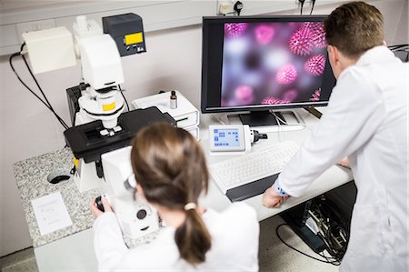 simsearch:6109-08389507,k - Scientist looking through a microscope Stock Photo - Premium Royalty-Free, Code: 6109-08389511