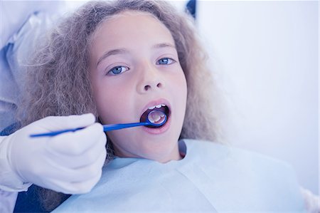 dentist bib girl - Dentist examining a patients teeth in the dentists chair Stock Photo - Premium Royalty-Free, Code: 6109-08389677