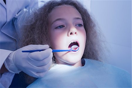 simsearch:6109-08389797,k - Dentist examining a patients teeth in the dentists chair Stock Photo - Premium Royalty-Free, Code: 6109-08389676