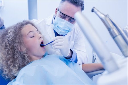 dentist bib girl - Pediatric dentist examining his young patient Stock Photo - Premium Royalty-Free, Code: 6109-08389703