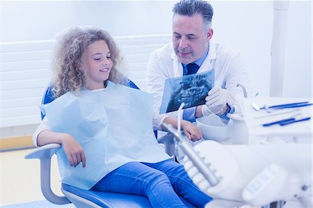 dentist bib girl - Pediatric dentist explaining to young patient the x-ray Stock Photo - Premium Royalty-Free, Code: 6109-08389701
